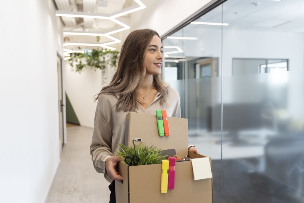 Woman with two boxes starting a new job in an office