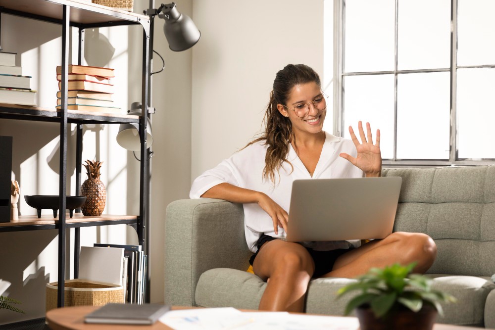 Woman working remotely form her house with her laptop